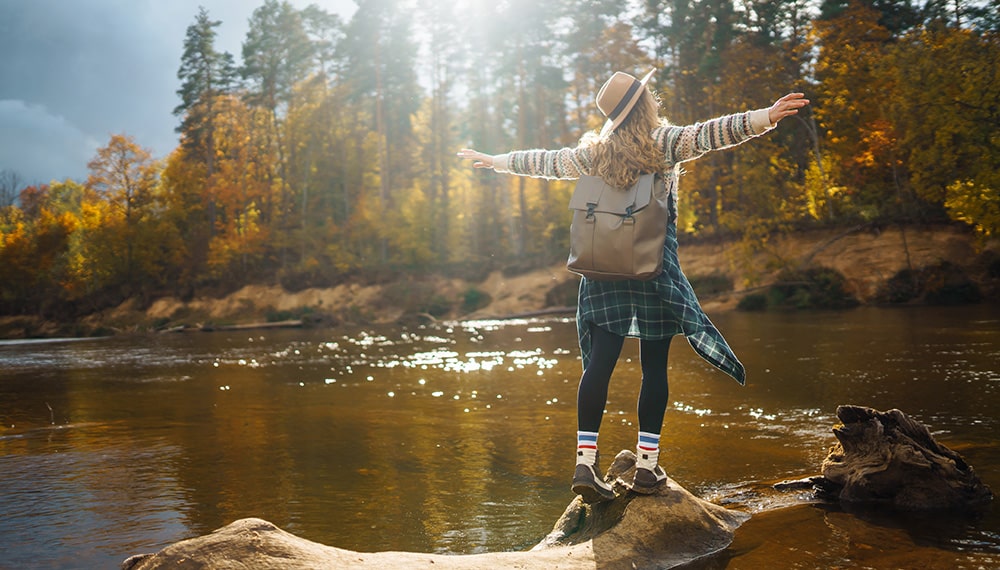 Glückliche Frau beim Spaziergang in einer herbstlichen Landschaft